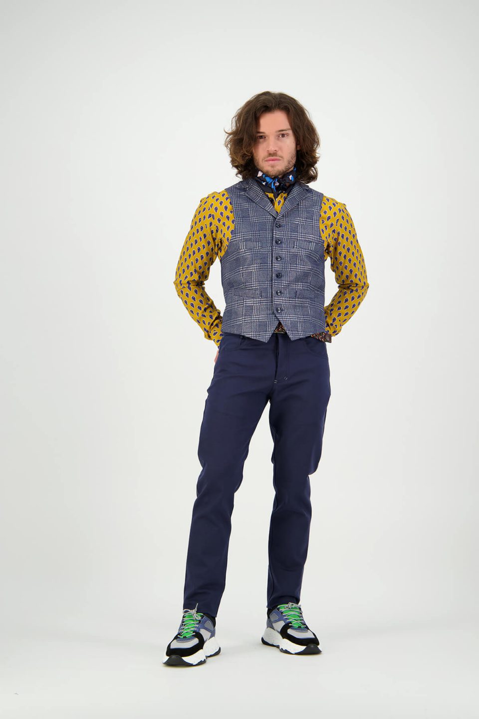 Male Fashion on-model photography in studio wearing blue vest, yellow shirt and blue pants