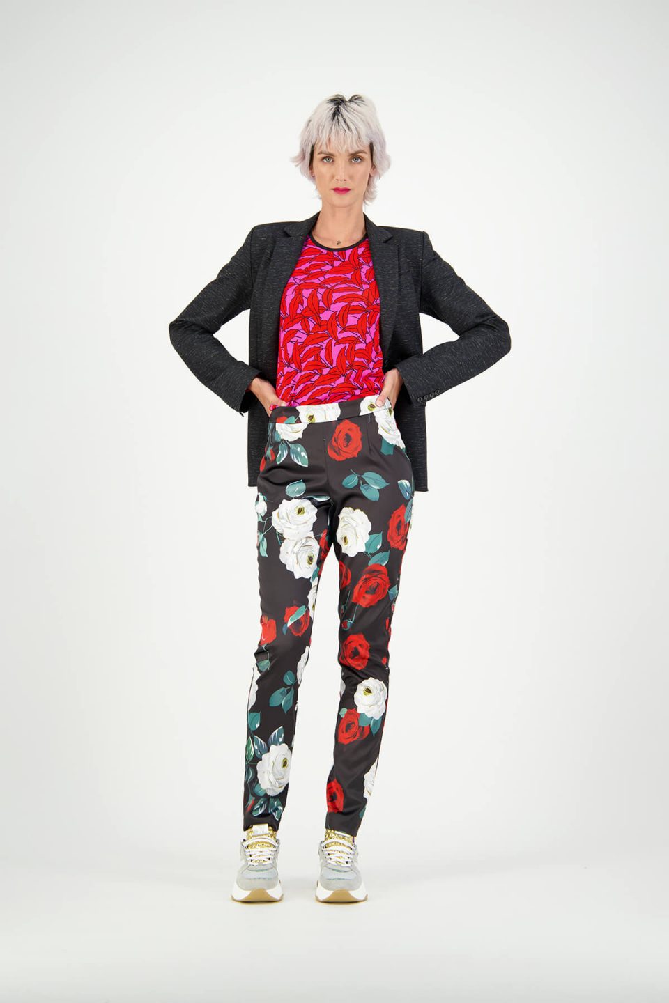 Women's fashion model studio photoshoot wearing floral pants, red tee and black blazer over the top