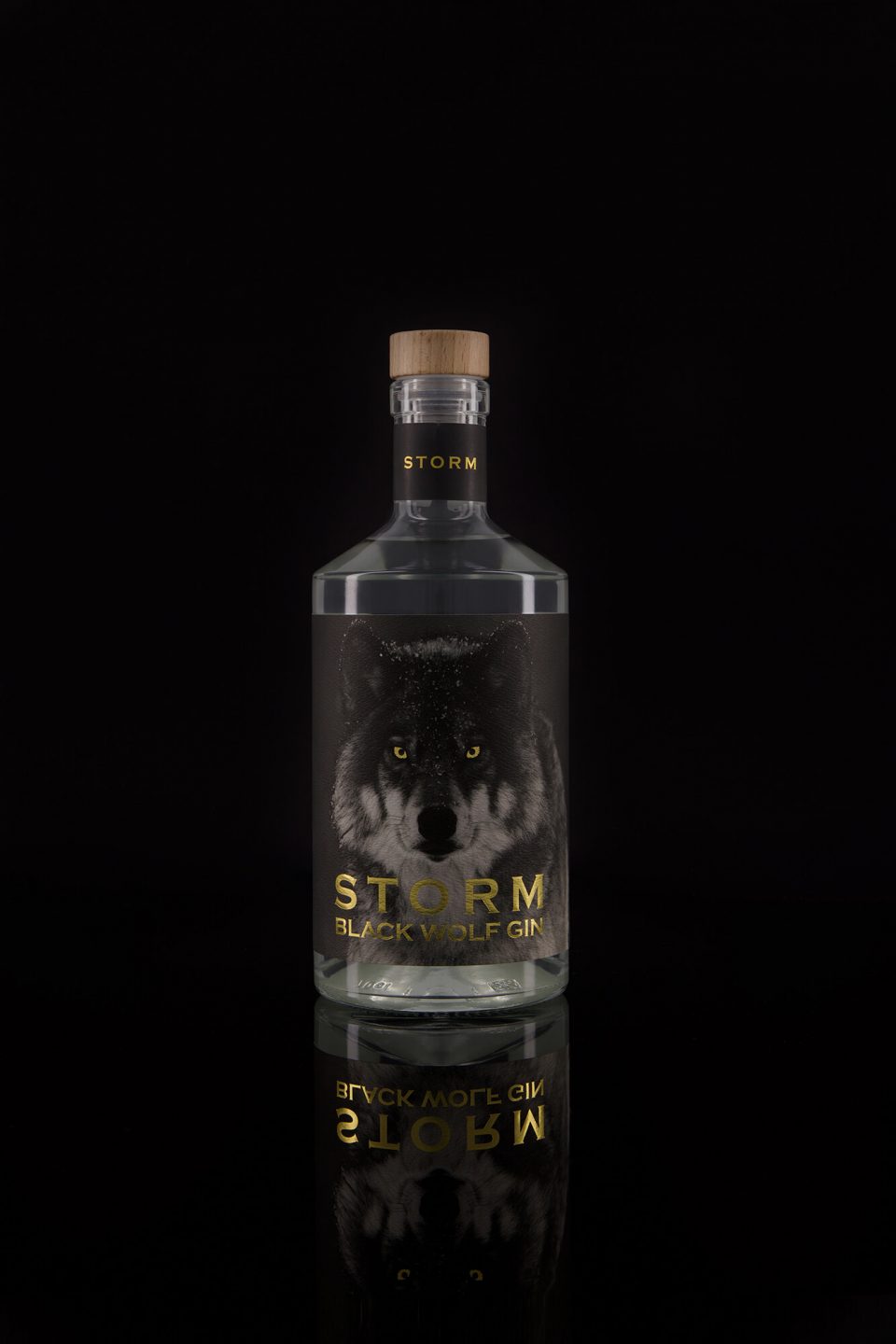 STORM Gin photographed on black background with gold reflections