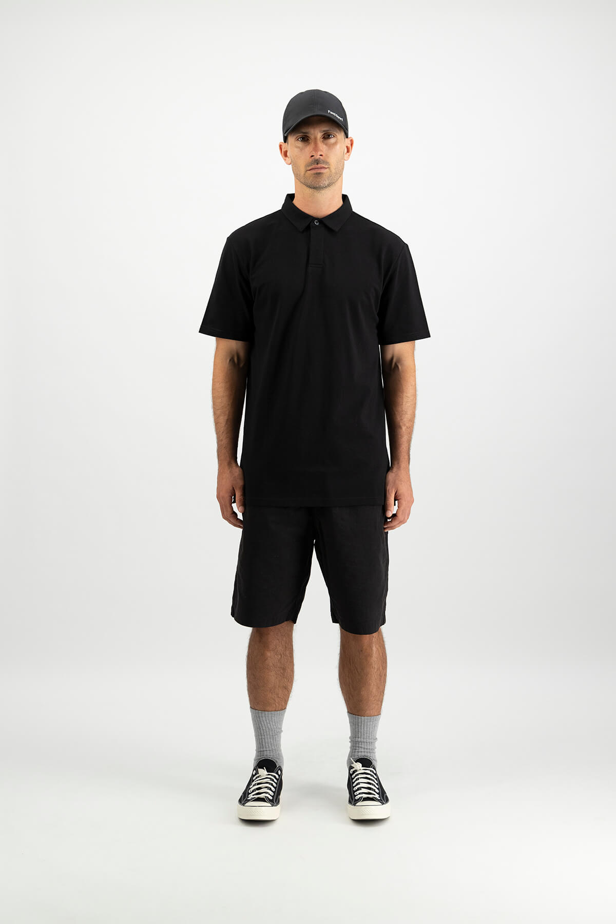 Fantl Sport male model wearing all black shorts and polo tee