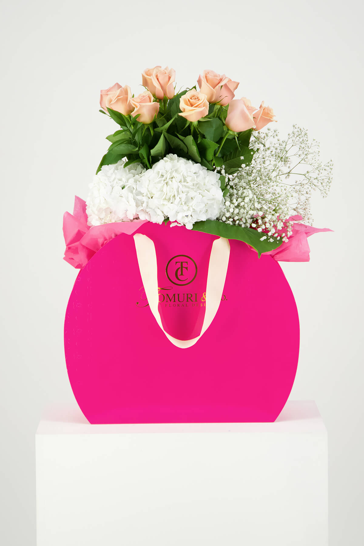 Pink roses and white flowers in pink box product photography Auckland Studio on white Plinth